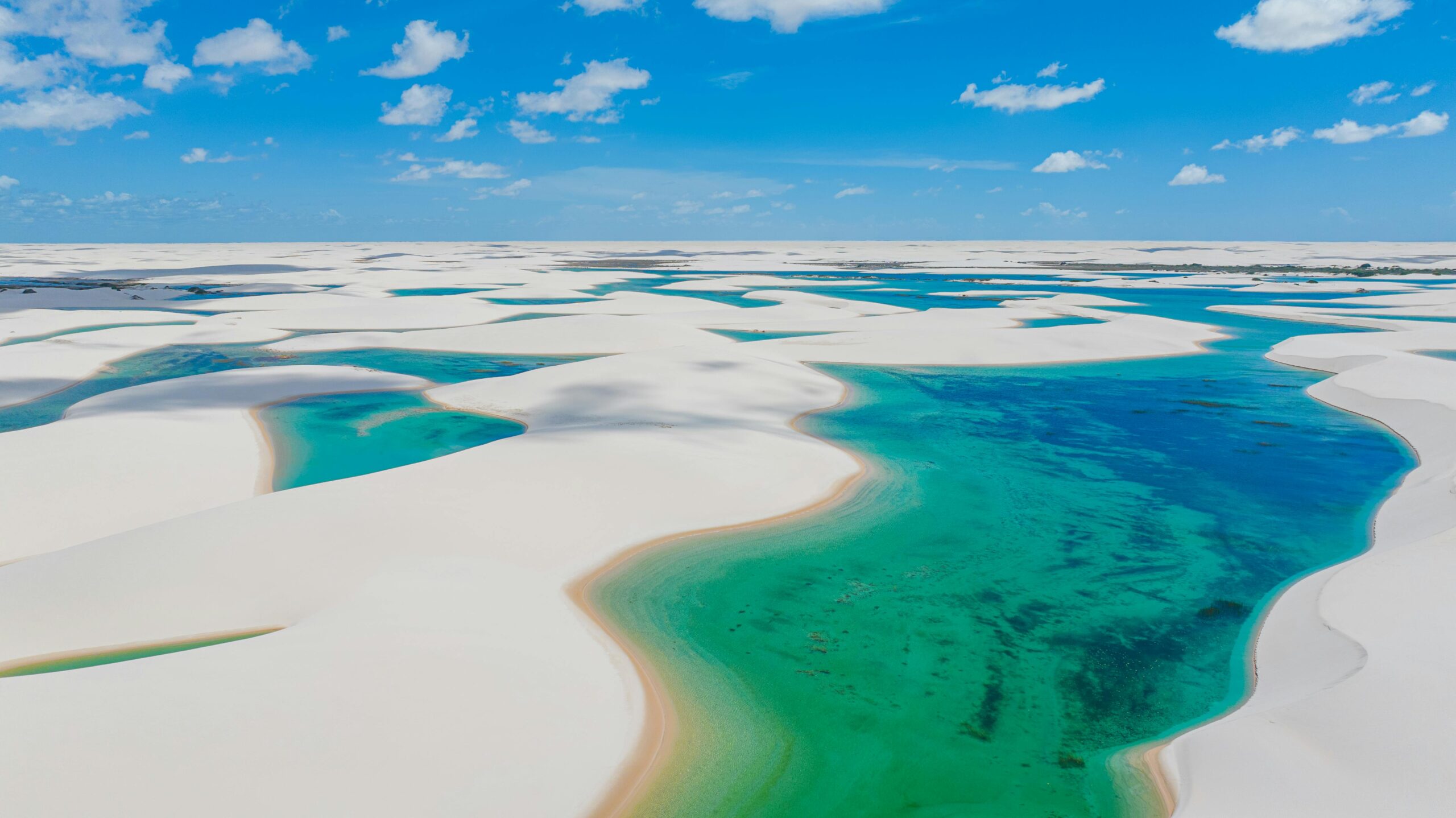 Stunning aerial view of the white sand dunes and turquoise lagoons in Lencois Maranhenses, Brazil.