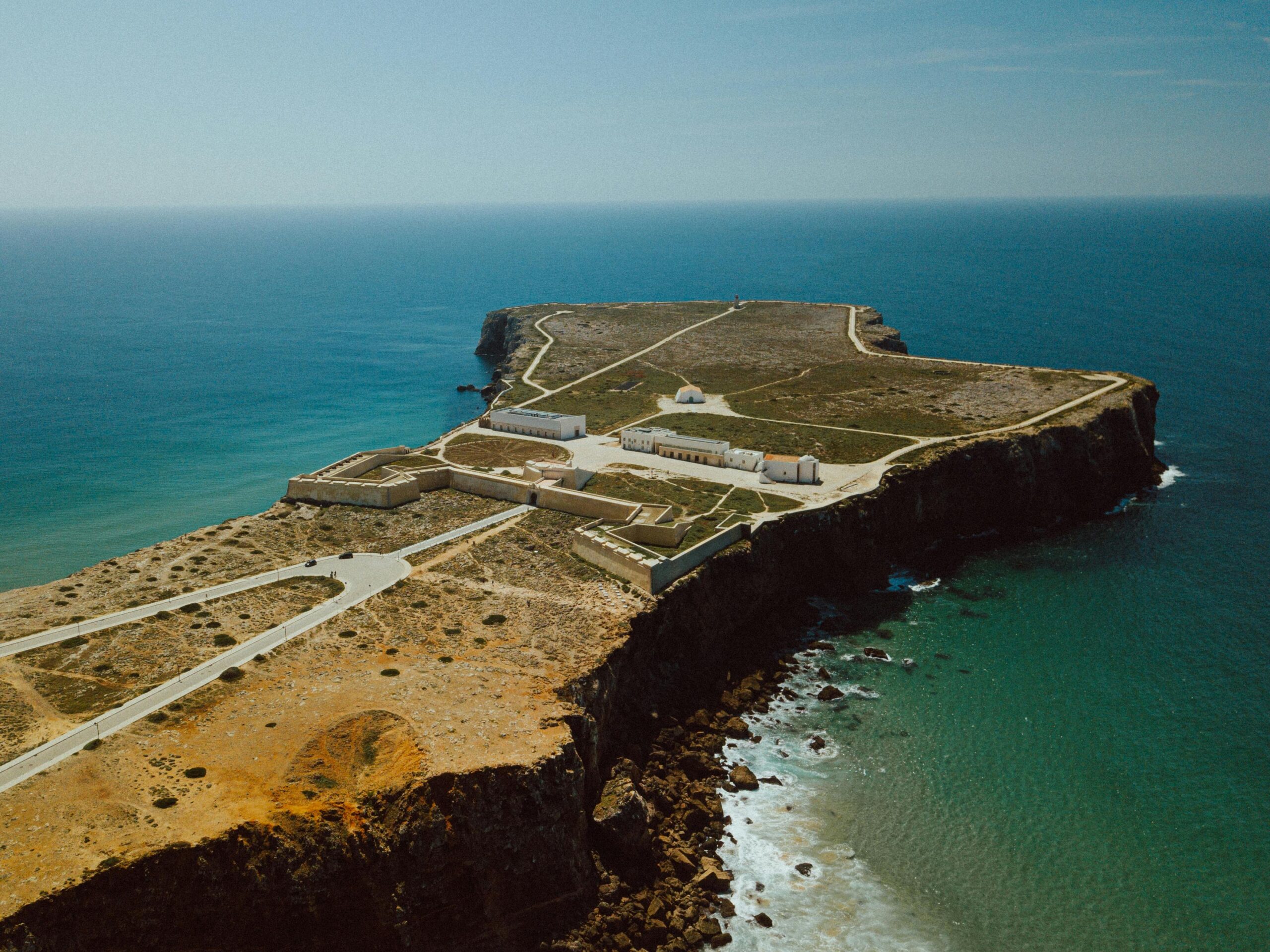 Aerial shot of the historic Sagres Fortress perched on a coastal cliff in Faro, Portugal.